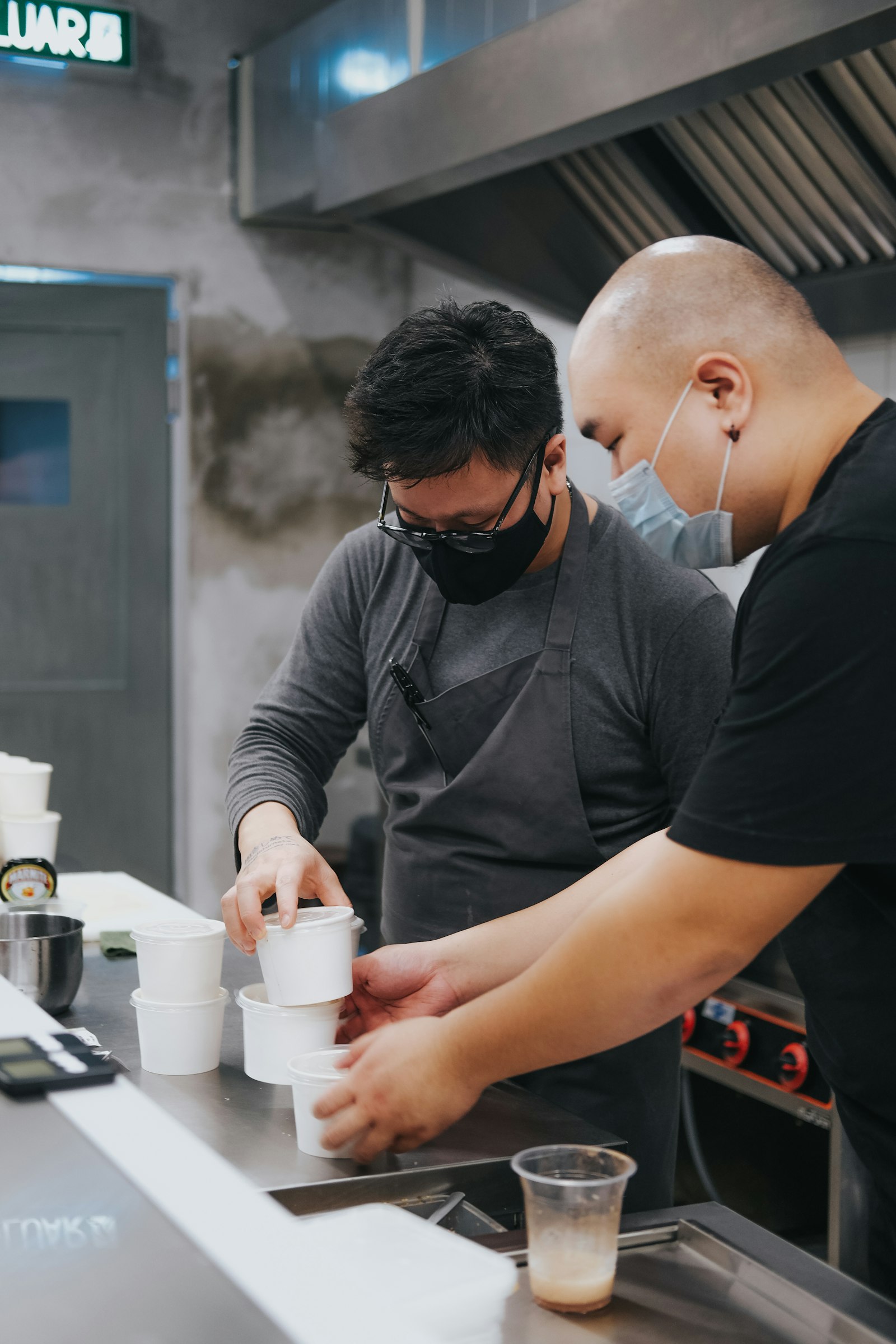 Two cooks preparing food side by side in a kitchen, leadership shown through teamwork